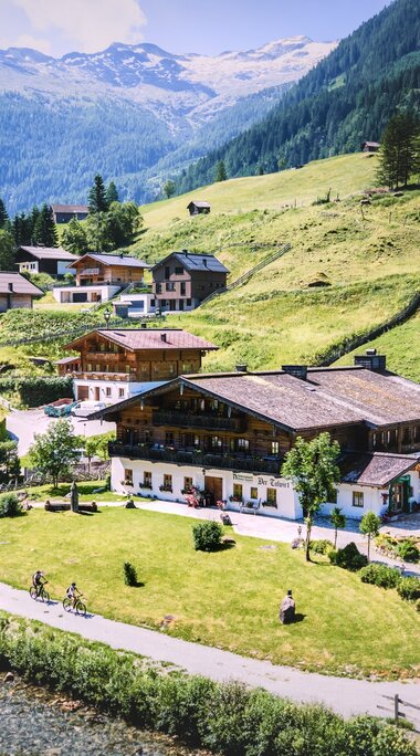 Alpine inn and houses in a green mountain valley. | © Daniel Kogler