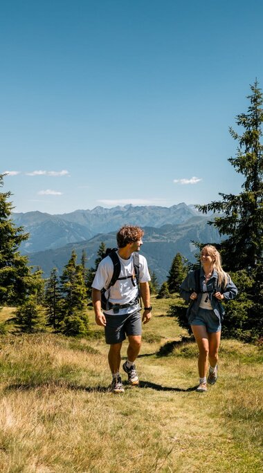 Two hikers on a meadow path near Piesendorf with views of the Hohe Tauern. | © Hohe Tauern National Park holiday region - Mathäus Gartner